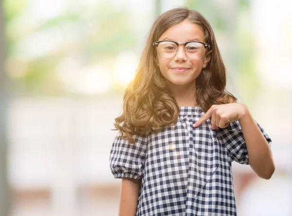 Morena Hispânica Menina Usando Óculos Com Rosto Surpresa Apontando Dedo — Fotografia de Stock