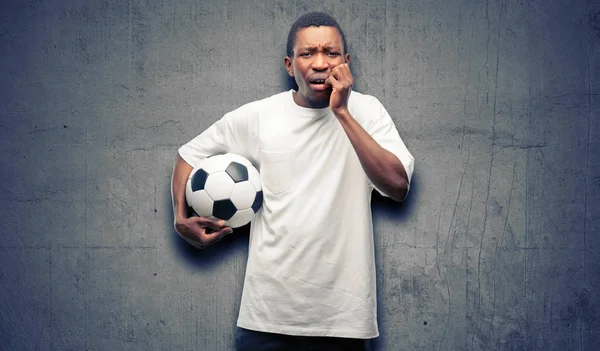 恐怖と不安とパニックのジェスチャー 圧倒を表現する神経にサッカー ボールを保持しているアフリカの黒人男性 — ストック写真