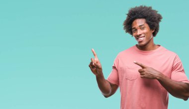 Gülümseyen ve iki elleri ve parmakları ile tarafına işaret kamera bakarak izole arka plan üzerinde Afro Amerikalı adam.