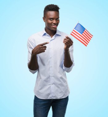 ABD bayrağı çok mutlu el ve parmak ile işaret tutan genç Afro-Amerikan adam