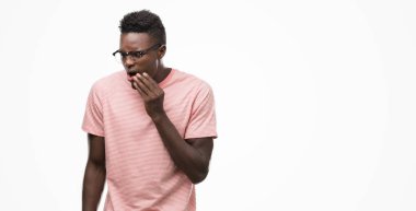 Diş ağrısı veya dişlerde dişlerle ilgili hastalık nedeniyle genç Afro-Amerikan adam giymiş pembe tişört dokunmadan ağız acı ifadesi ile el ile. Diş hekimi kavramı.