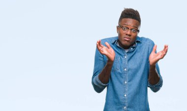 Afrikalı-Amerikalı genç izole arka plan clueless ve şaşkın bir ifadeyle kollar ve eller ortaya çıkar üzerinden. Şüphe kavramı.