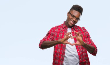 Afrikalı-Amerikalı genç aşık kalp simgesi ve elleriyle şekil gösteren gülümseyen izole arka plan üzerinde. Romantik kavramı.