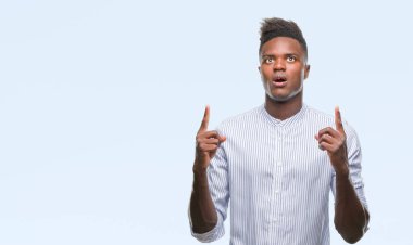 Genç Afro-Amerikan adam izole arka plan üzerinden hayran ve yukarıya bakıp parmakları ile işaret şaşırttı ve silah kaldırdı.