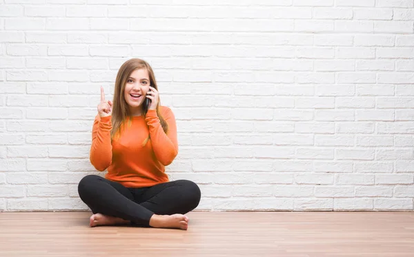 Junge Erwachsene Frau Sitzt Auf Dem Boden Über Weißen Ziegelwand — Stockfoto