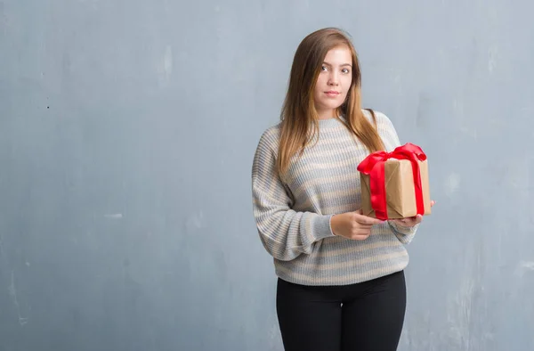 Young Adult Woman Grey Grunge Wall Holding Present Confident Expression — Stock Photo, Image
