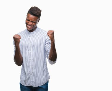 Gülümseyen ve başarı için çığlık genç Afro-Amerikan adam izole arka plan çok mutlu ve heyecanlı kaldırdı, silah ile kazanan jest yapıyor. Kutlama kavramı.