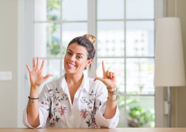 Genç kadın evde gösterilen ve parmak yedinci ile gülümseyen ise kendinden emin ve mutlu yukarı dönük.