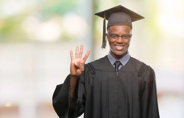 若者を示す孤立した背景の上のアフリカ系アメリカ人の卒業し 自信を持って 幸せな笑みを浮かべて 指で上向きナンバーフォー — ストック写真