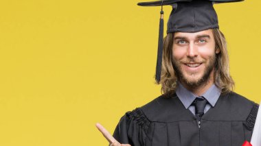 Genç yakışıklı adam uzun saçlı derecesi izole arka plan üzerinde çok el ve parmak ile tarafına işaret mutlu tutarak yüksek lisans