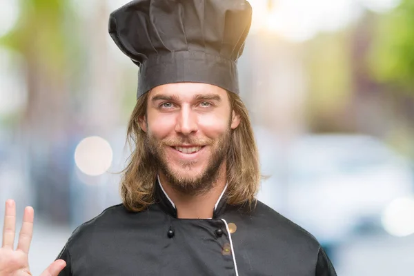 年轻英俊的厨师长头发在孤立的背景显示和指向五 而微笑着自信和快乐的手指数 — 图库照片