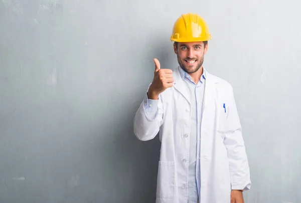 Guapo Joven Ingeniero Hombre Sobre Gris Grunge Pared Usando Casco —  Fotos de Stock