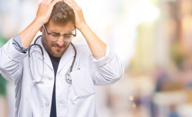 Genç yakışıklı Doktor adam çünkü umutsuz ve stresli baş ağrısı acı izole arka plan üzerinde ağrı ve migren. Ellerini kafasına.