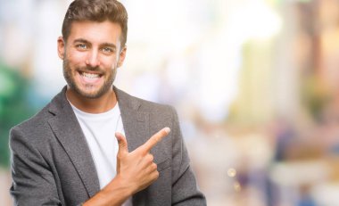 Genç yakışıklı iş adamı izole arka neşeli bir gülümseme ile el ve parmak kadar kameraya bakarak yüzündeki mutlu ve doğal ifade ile yan ile işaret yüz üzerinden.