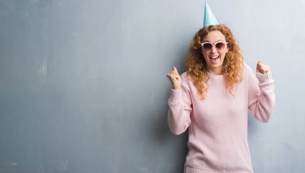 Joven Pelirroja Sobre Gris Pared Grunge Usando Gorra Cumpleaños Gritando —  Fotos de Stock