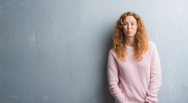 Mulher Ruiva Jovem Sobre Parede Grunge Cinza Vestindo Camisola Rosa — Fotografia de Stock