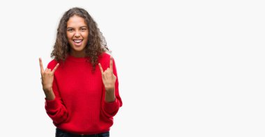 Deli ifade rock simge elle yapıyor ile kırmızı kazaklı bağırarak giyen genç İspanyol kadın. Müzik yıldızı. Ağır kavramı.