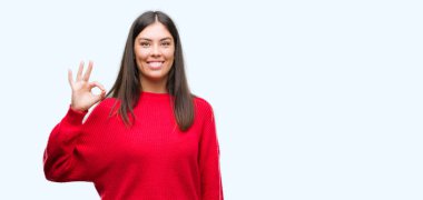 Genç güzel İspanyol giyen kırmızı kazaklı el ve parmaklar ok işaretiyle yapıyor olumlu gülümseyerek. Başarılı ifade.