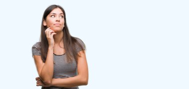 Çene düşünme hakkında soru, dalgın ifade üzerine el ile genç güzel İspanyol kadın. Düşünceli yüzüyle gülümsüyor. Şüphe kavramı.