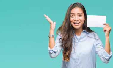 Kocaman bir gülümseme ile çığlık zaferini kutluyor ve ellerini kaldırdı izole arka plan çok mutlu ve heyecanlı, kazanan ifade üzerinde boş kartı tutan genç Arap kadın