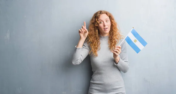 Unga Rödhårig Kvinna Över Grå Grunge Vägg Innehav Flagga Argentina — Stockfoto