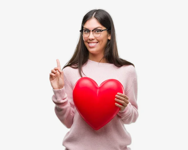 Mujer Hispana Joven Sosteniendo Corazón Amor Sorprendida Con Una Idea — Foto de Stock