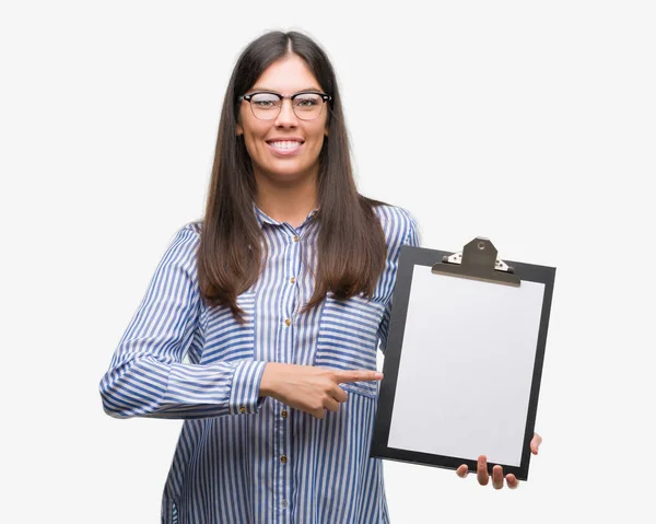 Mujer Hispana Joven Sosteniendo Portapapeles Muy Feliz Señalando Con Mano — Foto de Stock