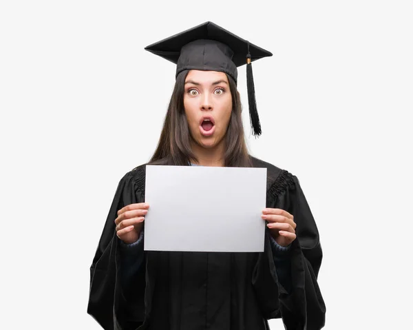 驚き顔 恐怖表現と興奮とショックで怖い卒業証書用紙を持って若いヒスパニック女性着て卒業制服 — ストック写真