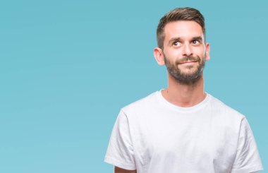 Yakışıklı delikanlı görünümlü yan ve dik dik bakma uzağa düşünce gülümseyen izole arka plan üzerinde.