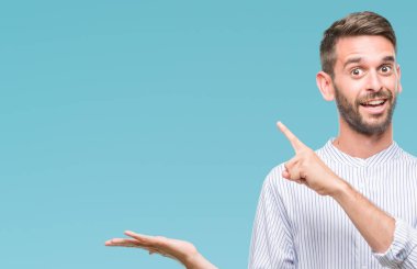 Yakışıklı delikanlı üzerinden hayran ve el ile sunulması ve parmak ile işaret ederken kameraya gülümseyen izole arka plan.