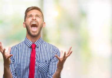 Genç yakışıklı iş adamı izole arka plan çılgın ve kızgın bağırarak ve agresif ifade ve silah kaldırdı bağırıyor. Hayal kırıklığı kavramı.