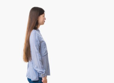 Genç Çinli kadın izole arka tarafına, seyir üzerinde dinlenmek doğal yüz emin gülümseme ile pozuyla profil.