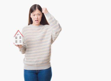 Genç Çinli gerçek durum Aracısı kadın izole arka plan holding evi rahatsız ve sinirli öfkeyle, çılgın ve yükseltilmiş eliyle diye bağıran öfke kavramı bağırarak.