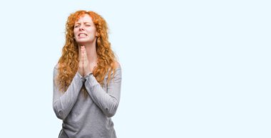 Yalvarıyor ve umut ifade yüzünde çok duygusal ve endişe ile birlikte elleriyle dua genç Kızıl saçlı kadın. Bağışlanmak. Din kavramı.