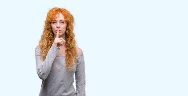 Dudaklarında parmak ile sessiz olmanı genç Kızıl saçlı kadın. Sessizlik ve gizli kavramı.