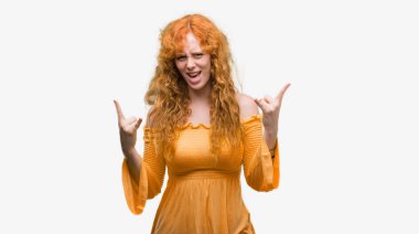 Deli ifade rock simge elle yapıyor ile bağırarak genç Kızıl saçlı kadın. Müzik yıldızı. Ağır kavramı.