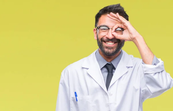成人西班牙裔科学家或医生穿白色大衣在孤立的背景下做 手势用手微笑 眼睛看通过手指与愉快的面孔 — 图库照片