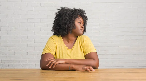 Jovem Afro Americana Sentada Mesa Casa Olhando Para Lado Relaxe — Fotografia de Stock