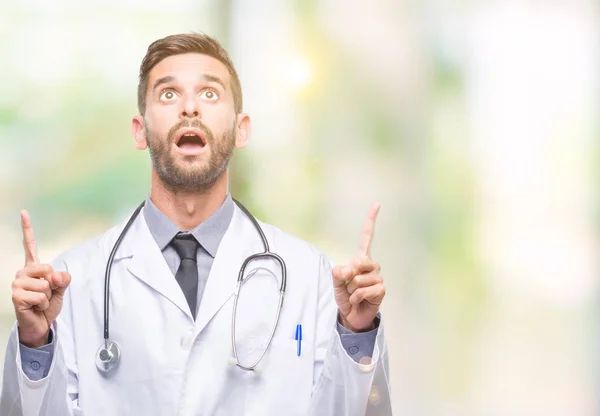 Young Handsome Doctor Man Isolated Background Amazed Surprised Looking Pointing — Stock Photo, Image