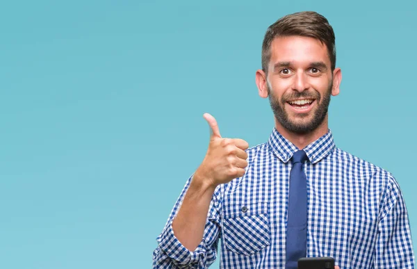 Ok işareti, başparmak ile parmak, mükemmel işareti yapıyor kocaman bir gülümseme ile arka plan mutlu genç atlatmışsınız adam manifatura üzerinden Smartphone kullanarak ileti gönderme izole