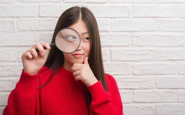 Jonge Chinese Vrouw Bakstenen Muur Kijken Vergrootglas Ernstige Gezicht Denken — Stockfoto