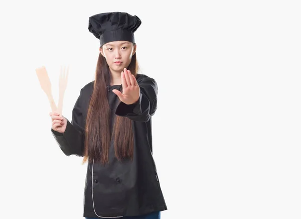 防衛ジェスチャー 深刻な自信を持って式に一時停止の標識を行うオープン手でシェフの制服を着て孤立の背景の上の若い中国の女性 — ストック写真