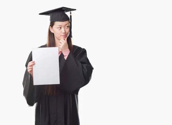 Mladá Číňanka Postgraduální Uniformě Drží Papír Stupeň Vážná Tvář Přemýšlet — Stock fotografie