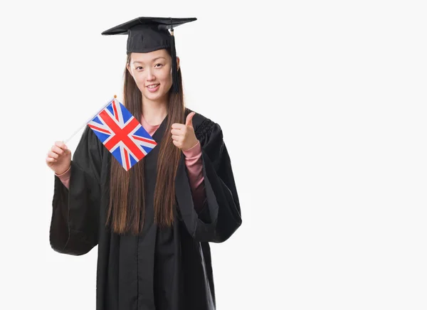 Jovem Chinesa Vestindo Uniforme Graduação Segurando Bandeira Reino Unido Feliz — Fotografia de Stock