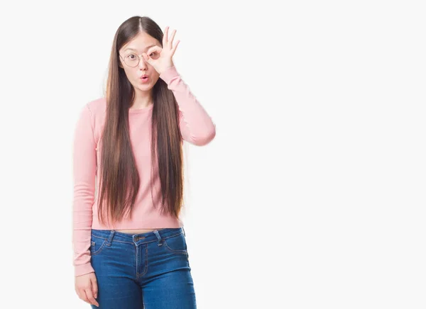 メガネ のジェスチャーを行う分離の背景の上の若い中国の女性は 驚いた顔 目指を通して見るとショックを受けた 疑うような式 — ストック写真