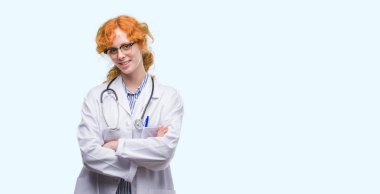 Doktor Tekdüzen mutlu yüz çapraz silah kameraya bakarak ile gülümseyen giyen genç Kızıl saçlı kadın. Olumlu bir kişi.