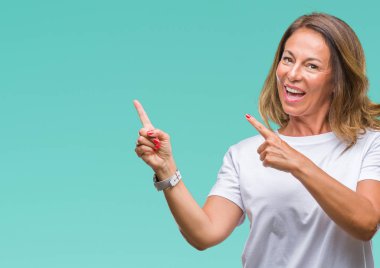 Orta yaş üst düzey İspanyol kadın gülümseyerek ve iki elleri ve parmakları ile tarafına işaret kamera bakarak izole arka plan.