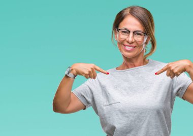 Orta yaş İspanyol kadın kıdemli gözlük ile kendine güvenen seyir izole arka plan üzerinde kendini gururlu ve mutlu parmakları ile işaret yüzündeki gülümseme.