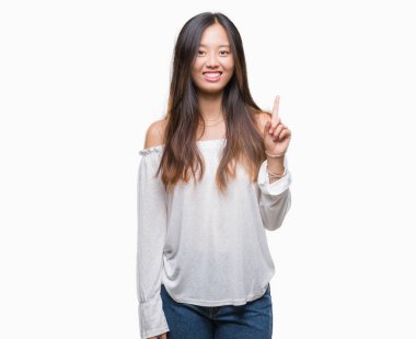 Genç Asyalı kadın ve kendinden emin ve mutlu gülümseyerek süre parmak numaralı yukarıyı gösteren izole arka plan üzerinde.