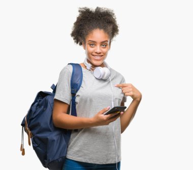 Sırt çantası sürpriz yüz işaret parmağı kendini izole arka plan üzerinde tutan genç güzel afro Amerikan öğrenci kadın